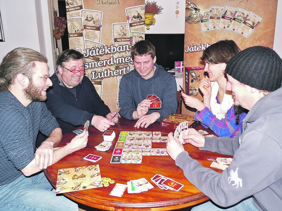 Auf die Plätze und los: Als der Entwickler des Spiels Domonkos Bence (Mitte) und Illustrator Áron Bence (l.) die ersten 100 Lutherspiele bei Thomas Lösche (2. v. l.) abgaben, wurde gleich ausgepackt und Probe gespielt.