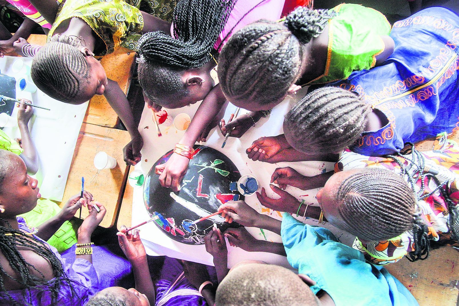 Kinder einer Schulklasse in Linkiring im Süden des Senegal malen auf Kalebassen ihre Erlebnisse bei Genital-
verstümmelungen. Die Mädchen zeichnen blutige Messer und Scheren, ein Junge malt ein weinendes Mädchen mit blutigem Unterleib. Die Genitalverstümmelung ist im Senegal seit 1999 verboten. Dennoch unterliegt immer noch schätzungsweise ein Viertel der Mädchen der grausamen Praxis