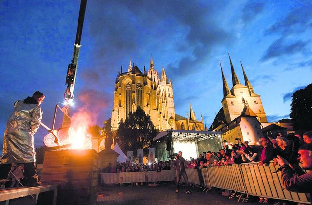 Fest gemauert in der Erden - Glockenguss 
zu Füßen des Doms: Glühendheiße Glockenbronze strömte auf dem nächtlichen Erfurter Domplatz vor der mächtigen Kulisse des Mariendoms in die Form für eine neue Glocke der Kirche St. Dionysius in Salomonsborn. Der Glockenguss war Teil des 300 Veranstaltungen umfassenden Programms mit dem Titel »Licht auf Luther«. Die am Himmelfahrtstag gegossene Glocke wurde zwei Tage später »entmantelt« und im Beisein vieler Schaulustiger zum ersten Mal erfolgreich angeschlagen. | Foto: epd-bild