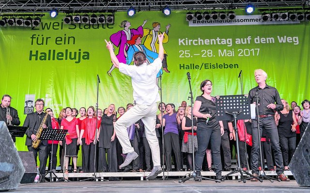 Ein Hoch auf die Musik: Dem Gospel widmete sich der Kirchentag auf dem Weg in Halle-Eisleben in besonderer Weise. Umgesetzt wurde dies zum Beispiel beim Gospel-Event unter dem Motto »One Way. One World. One Savior« am Freitag. Unter Leitung des Leipziger Kirchenmusikers Christoph Zschunke sangen Gospelchöre aus Hannover, Nordhausen und Berlin gemeinsam auf der großen Bühne am Markt. | Foto: epd-bild