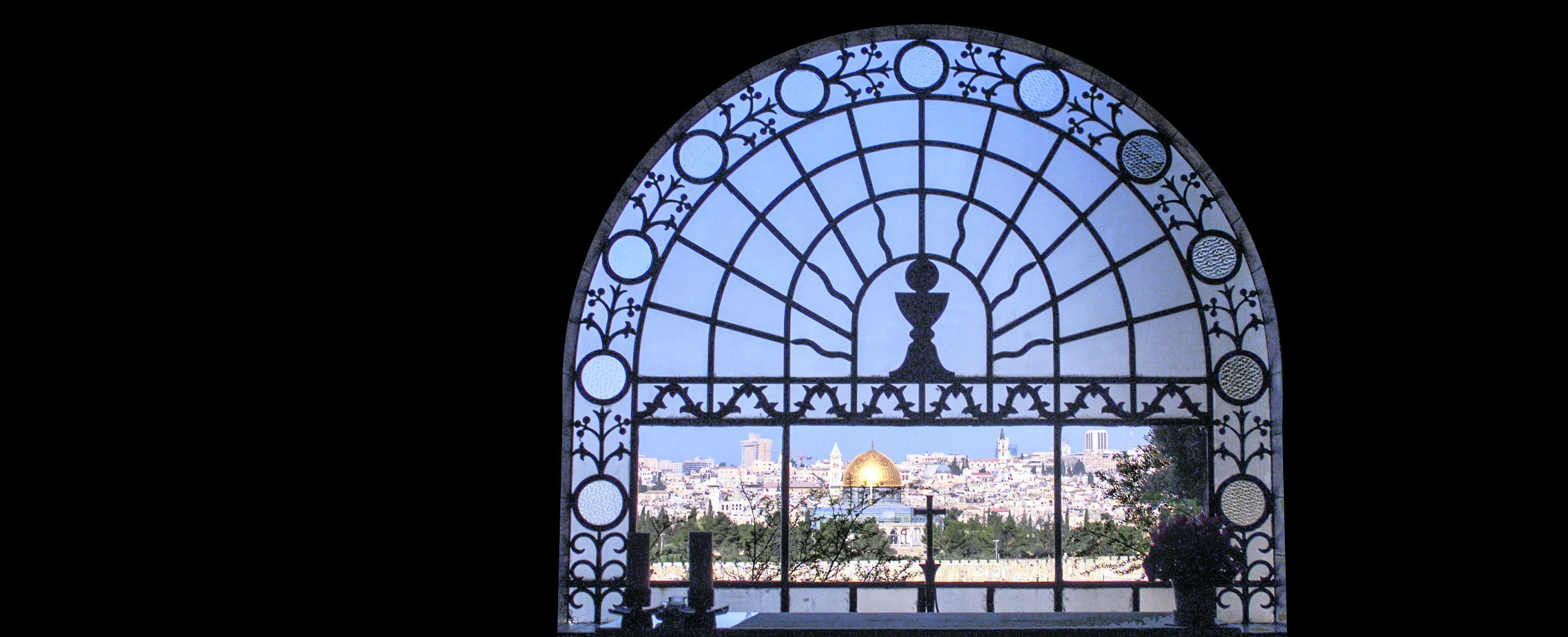 Blick auf die heilige Stadt durch das Fenster der Kirche »Dominus Flevit«. Das Altarkreuz weist auf die Grabeskirche (mit zwei Kuppeln), links daneben der Felsendom und der Kirchturm der evangelischen Erlöserkirche.
