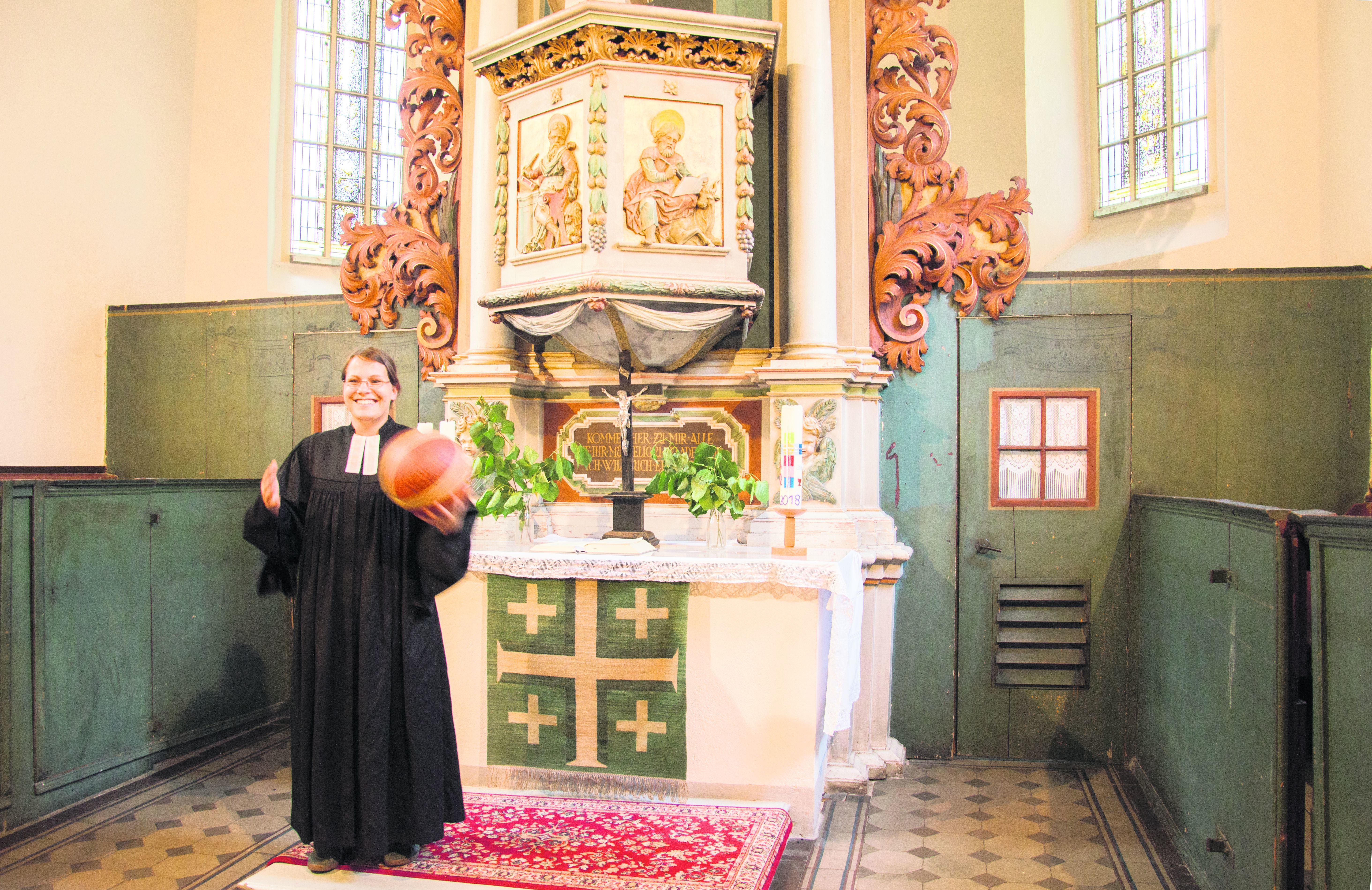 Sportlich im Talar: Pfarrerin Anna Mittermayer vor dem barocken Kanzelaltar von 1709 in
der Sandersdorfer Kirche St. Marien.