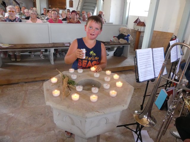 Constantin Lübbecke, der jüngste Radpilger, entzündet für jede Gemeinde eine Kerze beim Pilgergottesdienst in Elende. | Foto: Regina Englert