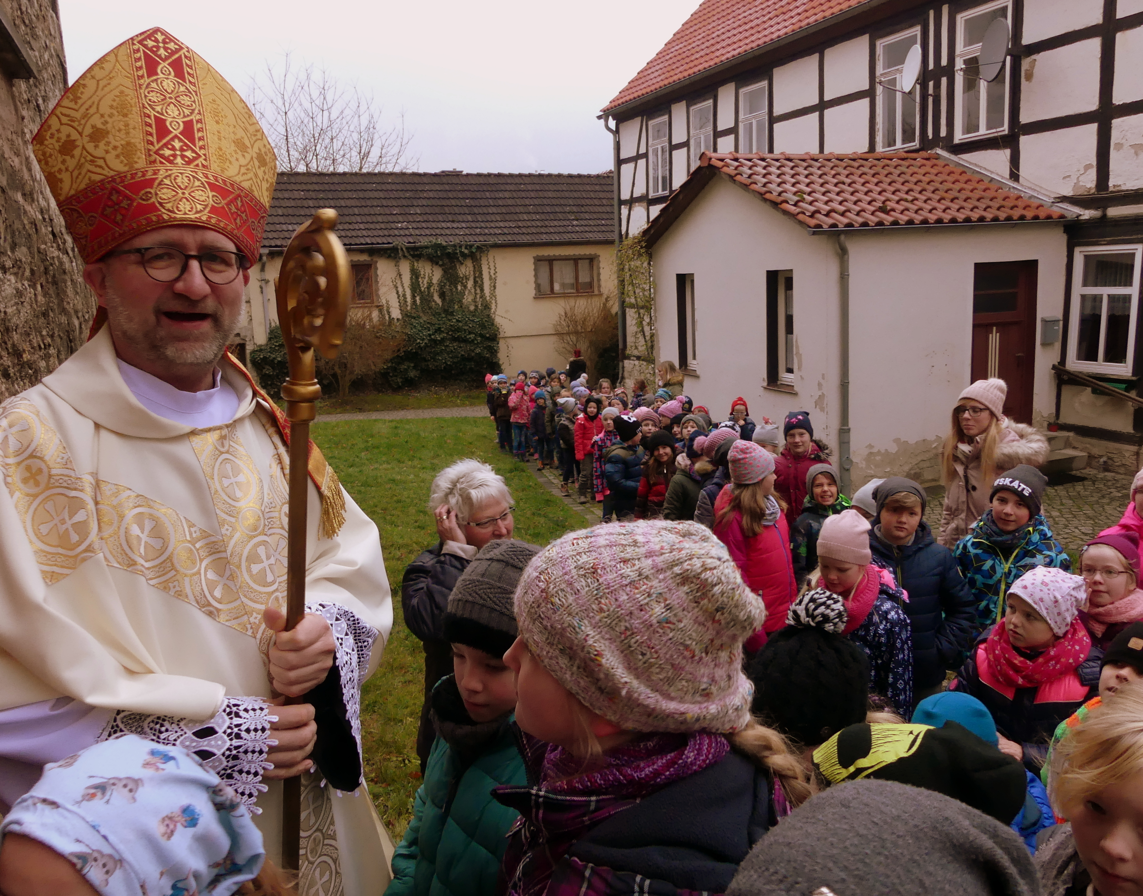 Endlich Einlass - der Nikolaus begrüßt die Schüler der Adolph Diesterweg Grundschule an der Kirchentür von St. Nicolai in Niedergebra persönlich.