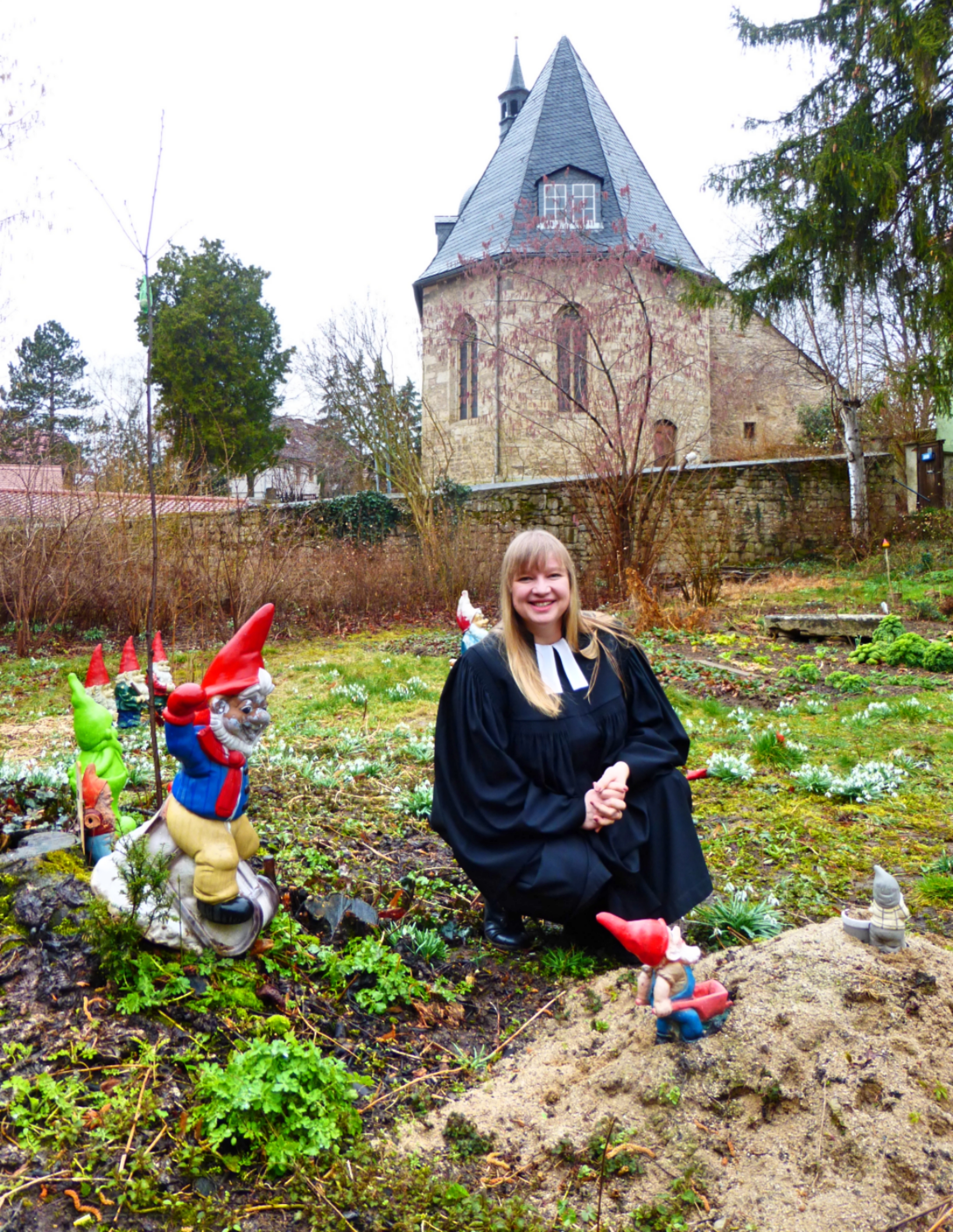 Auf Augenhöhe: Pfarrerin Jeanette Lorenz-Büttner in der Gartenzwerge-Ausstellung im Pfarrgarten in Magdala.