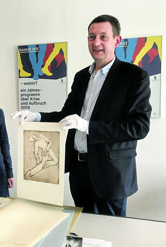 Ausstellungskurator Holger Zaunstöck mit einer neu erworbenen Grafik des Stiftungsschülers Wilhelm Krieg
