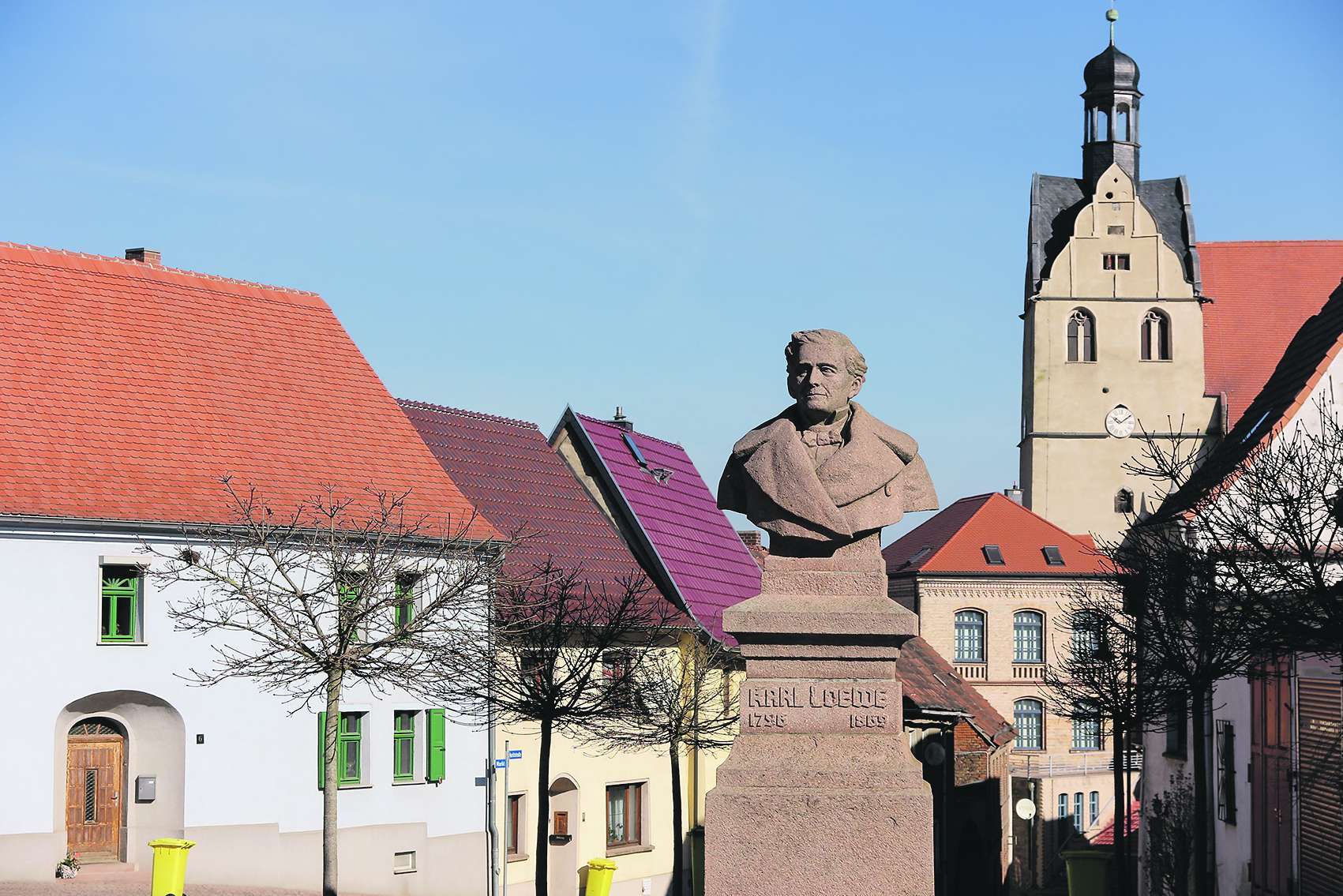 Denkmal für den Komponisten Carl Loewe, im Hintergrund die Kirche von Löbejün