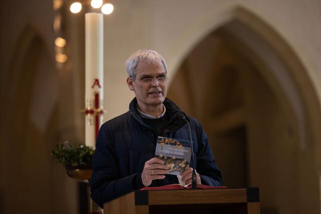 Anlässlich der Buga gibt es ein Buch zu Pflanzenmotiven in Erfurter Kirchen, das Senior Matthias Rein am Rande des Gottesdienstes vorstellte. | Foto: Paul-Philipp Braun 