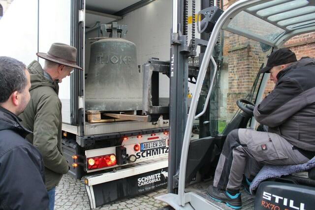 Pfarrer Albrecht Lindemann und Bürgermeister Andreas Dittmann beobachten wie Christian Keck die Glocke vom Transport hebt. | Foto: Petra Wiese