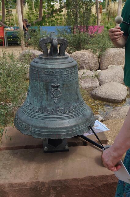 Eingeläutet wird sie durch diese Glocke, denn man wollte nicht nur zu sehen, sondern auch zu hören sein. Sie war 1755 im Auftrag des Kurfürsten Karl Theodor gegossen , 1975 an der Jesuitenkirche abgenommen und dann in einer Nebensakristei gelagert worden. Nun hervorgeholt, kann sie hier wieder von Zuversicht und Ermutigung künden.