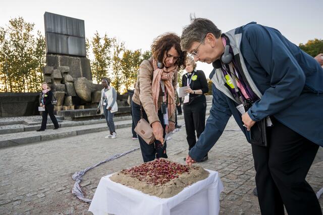 In dem früheren NS-Vernichtungslager Auschwitz-Birkenau haben Delegierte des Lutherischen Weltbundes  der mehr als einer Million Ermordeten gedacht.  Bischöfin Kristina Kühnbaum-Schmidt (Nordkirche) streut zum Gedenken an die Opfer in der Gedenkstätte Birkenau getrocknete Blüten. | Foto: epd-bild/ Thomas Lohnes