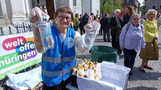 Wegzehrung: Birgit Heimann, frühere Mitarbeiterin in der Redaktion teilte nach dem Gottesdienst Laugengebäck und Wasser für die Teilnehmer am Festumzug von der Herderkirche zum Theaterplatz aus.  
 | Foto: EKM