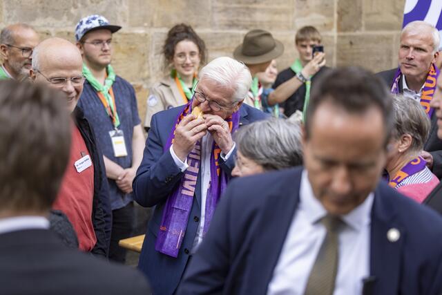 Das schmeckt: Bundespräsident Frank-Walter Steinmeier gönnt sich beim Rundgang an der Kirchenmeile eine echte Thüringer Bratwurst. | Foto: Foto: epd-bild/Paul-Philipp Braun