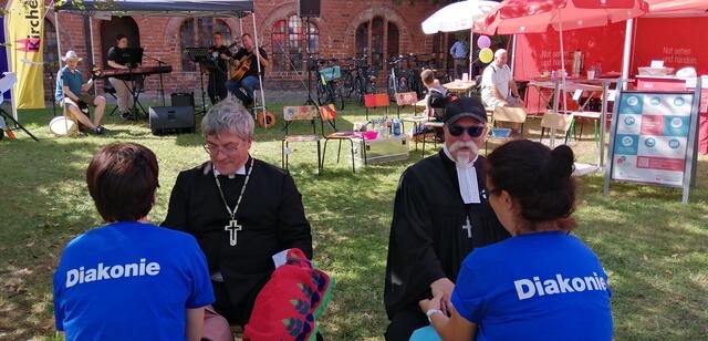 Landesbischof Friedrich Kramer und Stendals Superintendent Michael Kleemann haben nach dem Festumzug das ökumenische Kirchendorf besucht. Mitarbeiterinnen der Diakonie Wilhelmshof boten dort eine Handmassage an, die sie sonst Menschen im Hospiz angedeihen lassen. Bischof und Superintendent haben diese Form der Zuwendung sichtlich genossen.  | Foto: René Thumser
