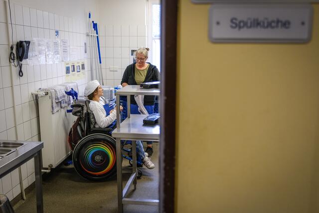 Teamarbeit: Küchenkraft Astrid (im Rollstuhl) mit Arbeitsassistentin Andrea Krüger in der Spülküche der Jugendherberge Goslar. | Foto: epd-bild/Jens Schulze