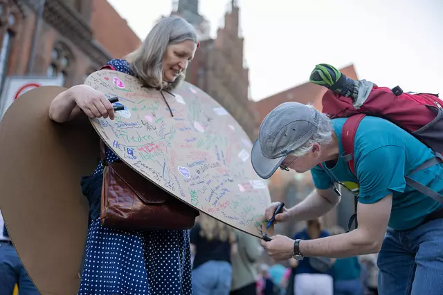 Mit ganzem Herzen dabei: Margitta aus Hannover lässt beim Abend der Begegnung auf ihr aus Pappe gebasteltes Herz Wünsche zu Liebe und Wärme schreiben.  | Foto:  epd-bild/Paul-Philipp Braun