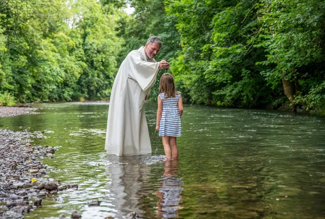 Pfarrer Christoph Knoll tauft ein Kind im Fluss. | Foto: Matthias Frank Schmidt