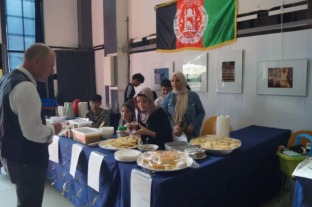 Frauen aus Afghanistan bieten traditionelle Gerichte zum Probieren.