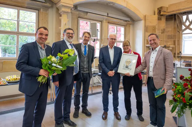 Empfang im Landeskirchenamt: Zum  Abschied in den Ruhestand überreichte G+H-Chefredakteur Willi Wild (r.) Stefan Große und seiner Frau eine Karikatur von NEL. Die Geschäftsführer des Wartburg Verlags, Sebastian Knöfel und Torsten Bolduan (v.l.) sowie der Geschäftsführer des EPD-Ost, Bert Wegener, wünschten Gottes Segen für den neuen Lebensabschnitt  | Foto: Matthias Frank Schmidt