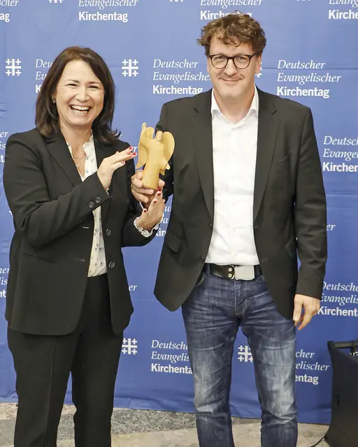 Staffelstabübergabe: Anja Siegesmund hat ihr Amt als Präsidentin des Kirchentages 2025 in Hannover an Torsten Zugehör übergeben – symbolisch mit einer kleinen Engelsfigur. | Foto: Kirchentag/Mario Zeißig
