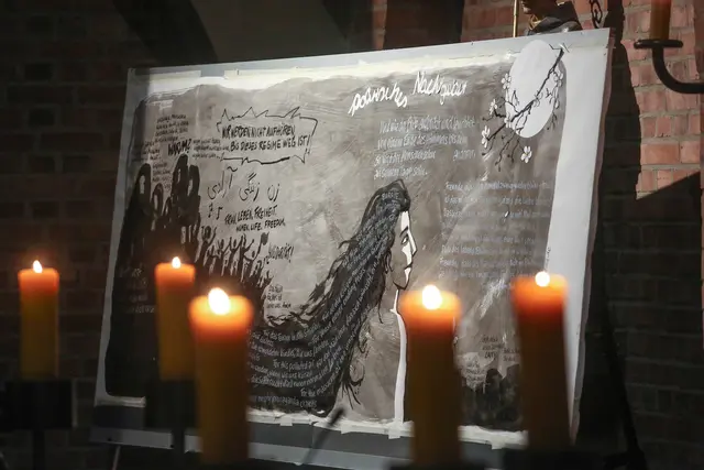 2023: Ein Wandbild mit Bildern und Gedanken zu den Protesten gegen das Mullah-Regime im Iran steht während eines politischen Nachtgebets der Evangelischen Kirche im Rheinland in der Kirche St. Albertus Magnus in Düsseldorf.  | Foto: epd-bild/Hans-Jürgen Bauer