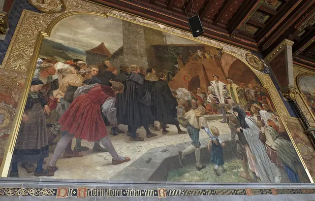 Wo Luther sich um das Abendmahl stritt: Das Wandgemälde in der alten Aula der Marburger Universität zeigt das Religionsgespräches zwischen Luther und Zwingli und anderen Reformatoren auf Einladung des Landgrafen Philipp von Hessen Versammelt war die theologische Elite der Zeit: Luther, der gemeinsam mit Philipp Melanchthon aus Wittenberg angereist war, Huldrych Zwingli aus Zürich und Martin Bucer aus Strassburg, Justus Jonas aus Sachsen, weitere damals bekannte Theologen, Ratsherren und Militärs. Das Gespräch sollte einen Streit zwischen Luther und Zwingli um das Abendmahlsverständnis beilegen. Die Einigung scheiterte. | Foto: epd-bild/Norbert Neetz