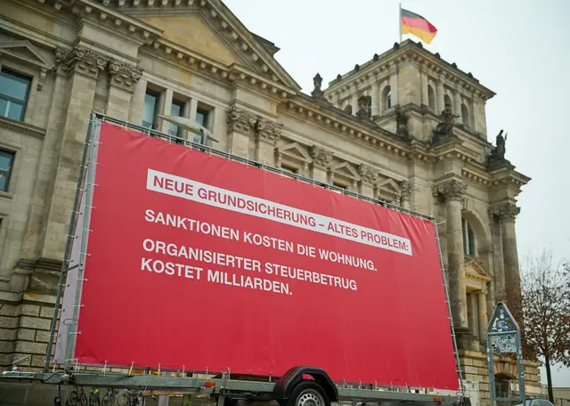 Sozialverbände und Gewerkschaften fordern auf einem am Donnerstag (15.01.2026) vor dem Bundestag in Berlin enthüllten Großplakat die Abgeordneten auf, bei der Bürgergeld-Reform nachzubessern | Foto: epd-bild/Christian Ditsch
