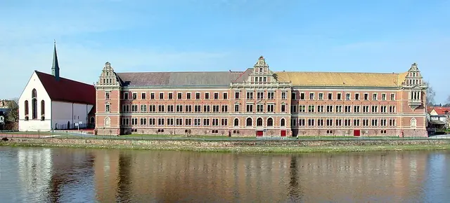 Gymnasium St. Augustin von der Mulde aus, links die Klosterkirche Grimma | Foto: Jörg Blobelt, CC BY-SA 4.0, https://commons.wikimedia.org/w/index.php?curid=77546024