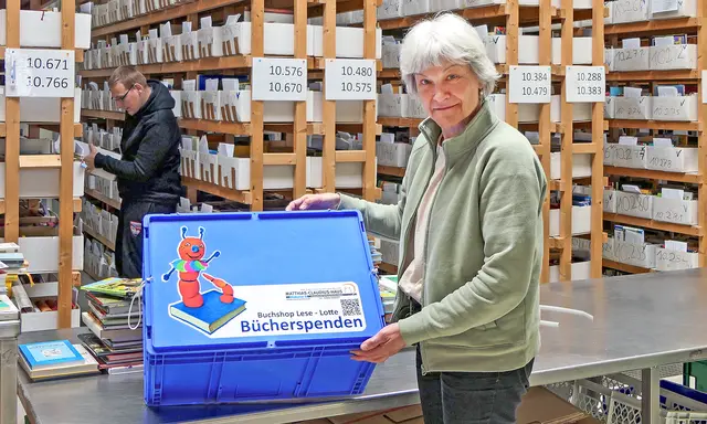 Im Bücherlager: Teamleiterin Andrea Senft zeigt eine der Spendenboxen, die an mehreren Orten in und um Oschersleben zu finden sind. | Foto: Foto: Claudius-Haus-Stiftung/Sabrina Gorges