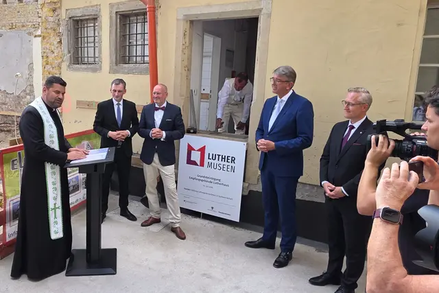 Segensworte zur Grundsteinlegung von Pfarrer Samuel Nánási, Studienleiter des Lutherischen Weltbundes in Wittenberg. An seiner Seite (von links): Sachsen-Anhalts Bildungsminister Jan Riedel, Thomas T. Müller von der Stiftung Luthergedenkstätten, Maurermeister Maximilian Wegener , Kulturstaatsminister Wolfram Weimer und Wittenbergs Bürgermeister Andé Seidig. | Foto: Thomas Nawrath