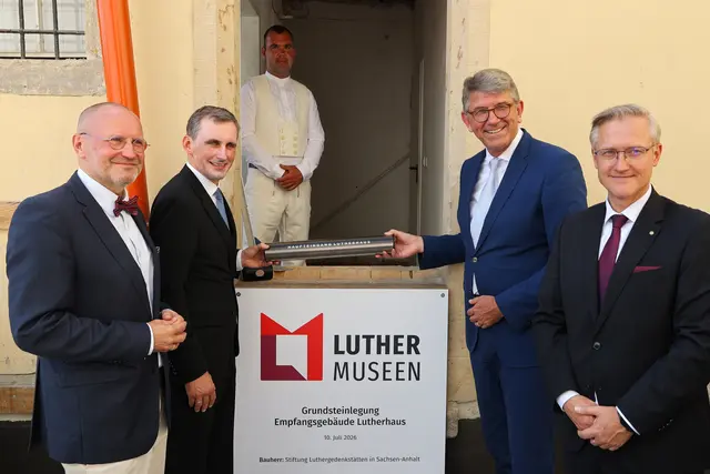 Luthergedenkstätten-Stiftungsvorstand Thomas T. Müller, Sachsen-Anhalts Bildungsminister Jan Riedel, Kulturstaatsminister Wolfram Weimer und Wittenbergs Bürgermeister André Seidig "versenkten" zur Grundsteinlegung am 10. Juli 2026 diue Zeitkapsel für die Nachwelt, die von Mauermeister Maximilian Wegener eingemauert wurde. | Foto: Thomas Nawrath