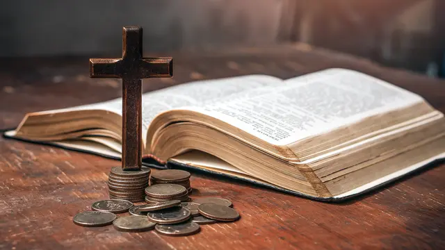 Geld, Kreuz und Bibel: Schließen Wohlstand und frommes Leben sich aus oder können sie sich ergänzen? | Foto: witsarut – stock.adobe.com