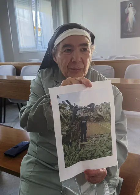 Die 78-Jaehrige Schwester Maria Salvatore in der Container-Kirche Sant’Agostino in Amatrice in Mittelitalien. Bei dem Erdbeben wurde sie unter den Truemmern des Konvents, in dem sie lebte, verschuettet. Hier zeigt sie ein Foto. | Foto:  epd-bild/Almut Siefert