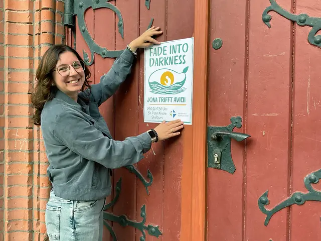 Pfarrerin Dr. Johanna Reitmeier-Filax präsentiert das Veranstaltungsplakat an der Kirchentür der St.-Petri-Kirche Staßfurt.