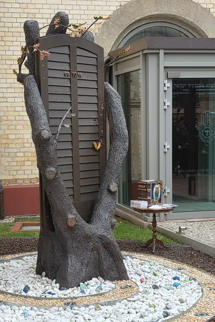 Das Denkmal "neun - zehn - neunzehn" mit der integrierten alten Eingangstür der Synagoge samt Einschusslöchern symbolisiertzugleich die schützende Hand (Gottes), die auf wundersame Weise die 52 Menschen bewahrtem die am 9. Oktober 2019 in der Synagoge Jom Kippur feierrn wollten. | Foto: Thomas Nawrath