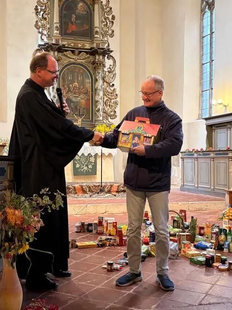 Pfarrer lard Reinhardt übergibt Martin Besen ein Geschenk. | Foto: Elisabeth Schöley